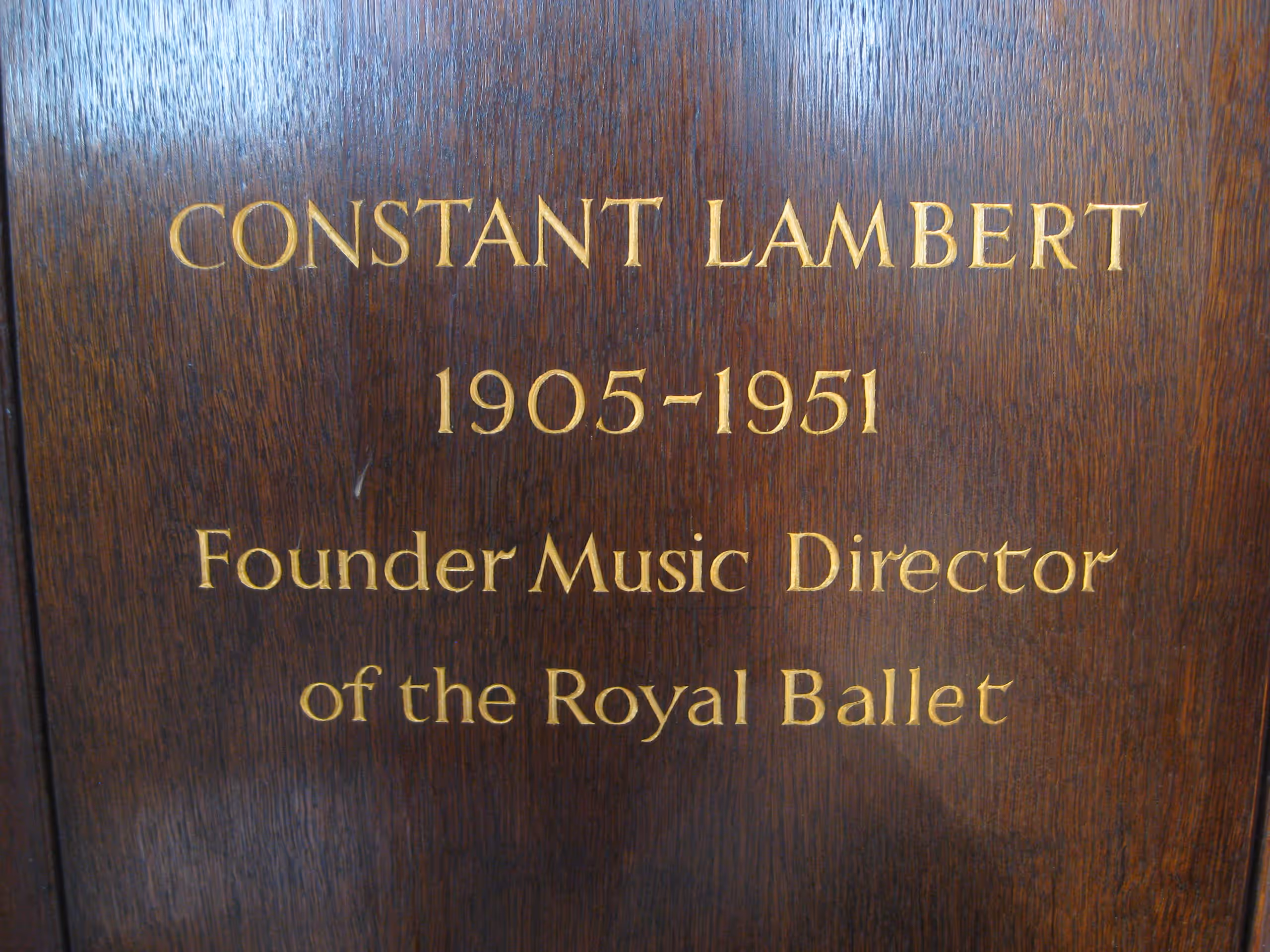 Wooden plaque reading 'Constant Lambert 1905–1951, Founder Music Director of the Royal Ballet'.