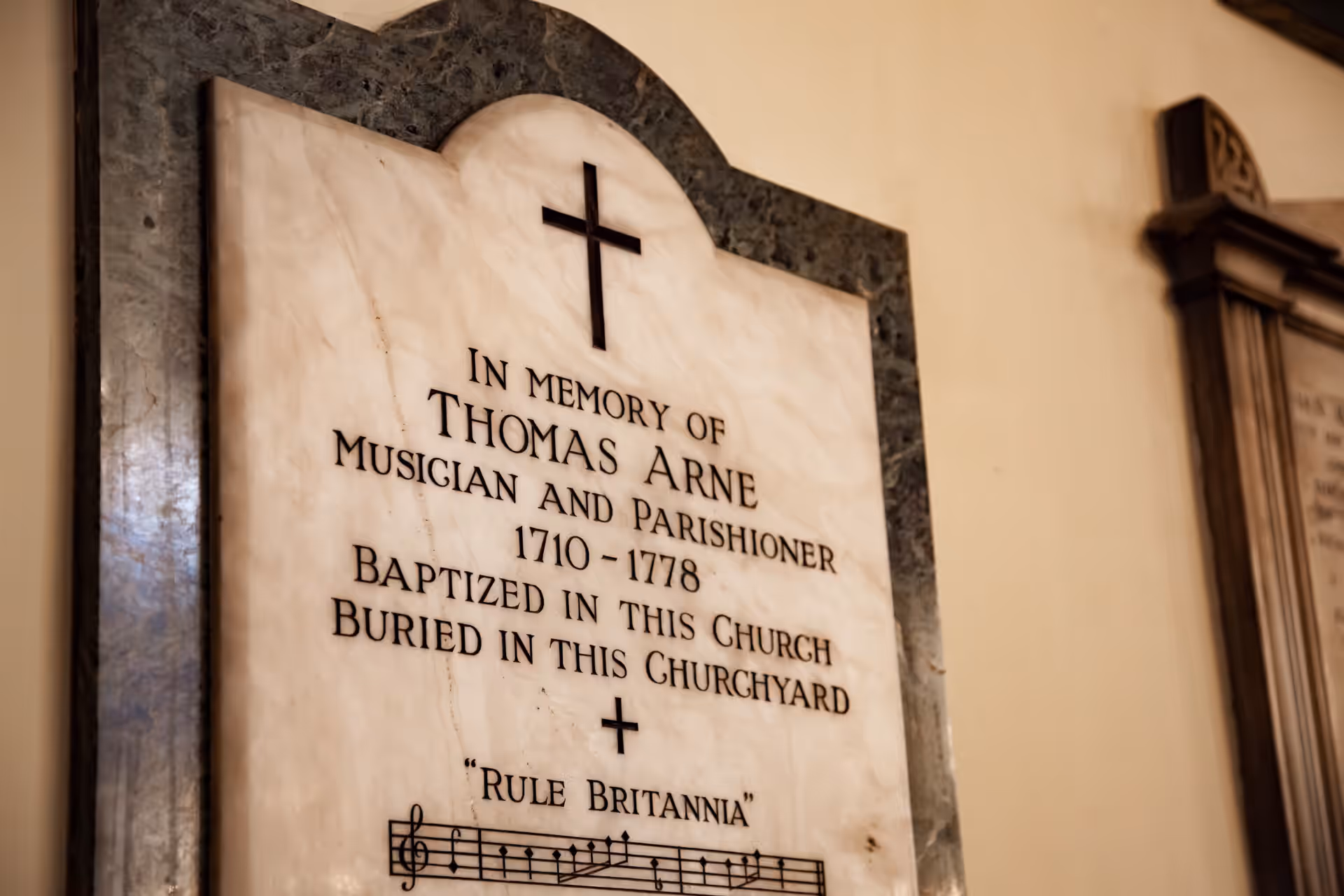 Marble memorial to Thomas Arne, musician and parishioner, 1710–1778, baptised and buried here, with bars of 'Rule Britannia'.